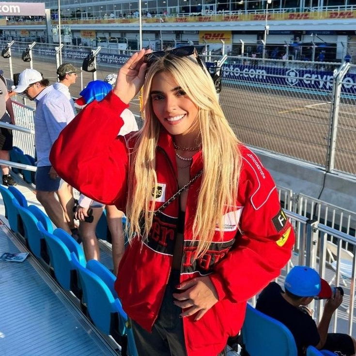 Woman in a red jacket at a race track event